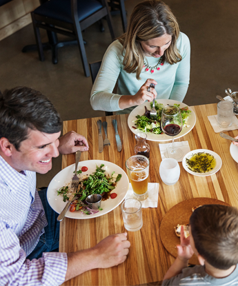 A family enjoying a salad at a restaurant